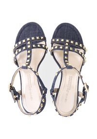 Denim-Sandalen mit einem Riemendesign, goldenen Nietenakzenten, einer gepolsterten Innensohle und verstellbaren Knöchelriemen. Farbe: dunkelblau.