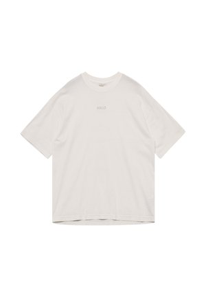 Biały koszulka oversize z krótkim rękawem, okrągłym dekoltem i nadrukiem "HALO" w małych, jasnoszarych literach na środku klatki piersiowej.