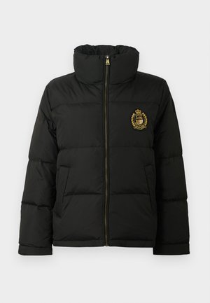 Fekete pufferedő kabát magas gallérral, elülső cipzárral, oldalsó zsebekkel és egy arany hímzett címerrel a bal mellkason.