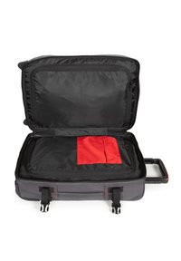 Black fabric suitcase with red interior pocket, rectangular shape, dual zippers, and a retractable handle, designed for organizational storage.