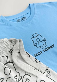 Ljusblå bomullströja med svart tecknad grafik och texten "NOT TODAY." Grå joggerbyxor med svarta abstrakta mönster och dragsko.