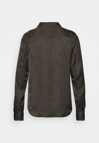 Tmavě zelená saténová košile s jemným květinovým vzorem, dlouhými rukávy a límcem na knoflíky. Zadní část obsahuje sedlo a smyčku na zavěšení.