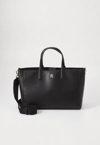 Sort læderhåndtaske med to øverste håndtag og en justerbar rem. Har en guldfarvet logoaccent og en struktureret, rektangulær form.