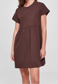 Hnědá bavlněná šaty s krátkými ohrnutými rukávy, kulatým výstřihem a nabraným pasem. Hladký materiál, délka po kolena, volnočasový design.