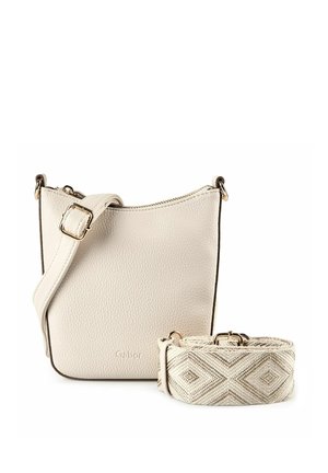 Bolso bandolera pequeño de cuero beige con correa ajustable incluida y una correa separada de tela estampada al lado.