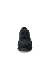 Black sneaker featuring a mix of smooth and textured materials, round toe, and a lace-up design. Rubber outsole with tread for grip.