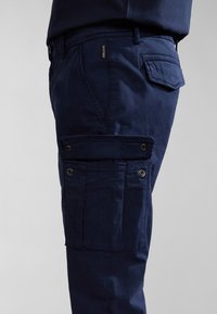 Navy blue cargo pants made of cotton, featuring side pockets with snap closures and standard back pocket, smooth texture and straight cut.