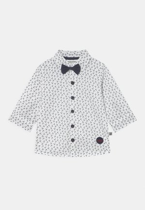 Chemise blanche pour bébé à manches longues avec petit motif d'ancre noire, boutons noirs et un nœud papillon noir au col.