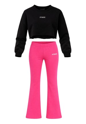 Felpa nera corta con scritta bianca "PYREX" e pantaloni a zampa a vita alta di colore rosa acceso con logo bianco "PYREX" abbinato.