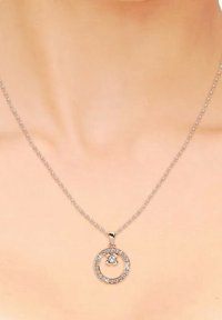 Collana in argento con pendente circolare decorato con cristalli trasparenti, che mette in risalto un gioiello centrale e un design circolare.