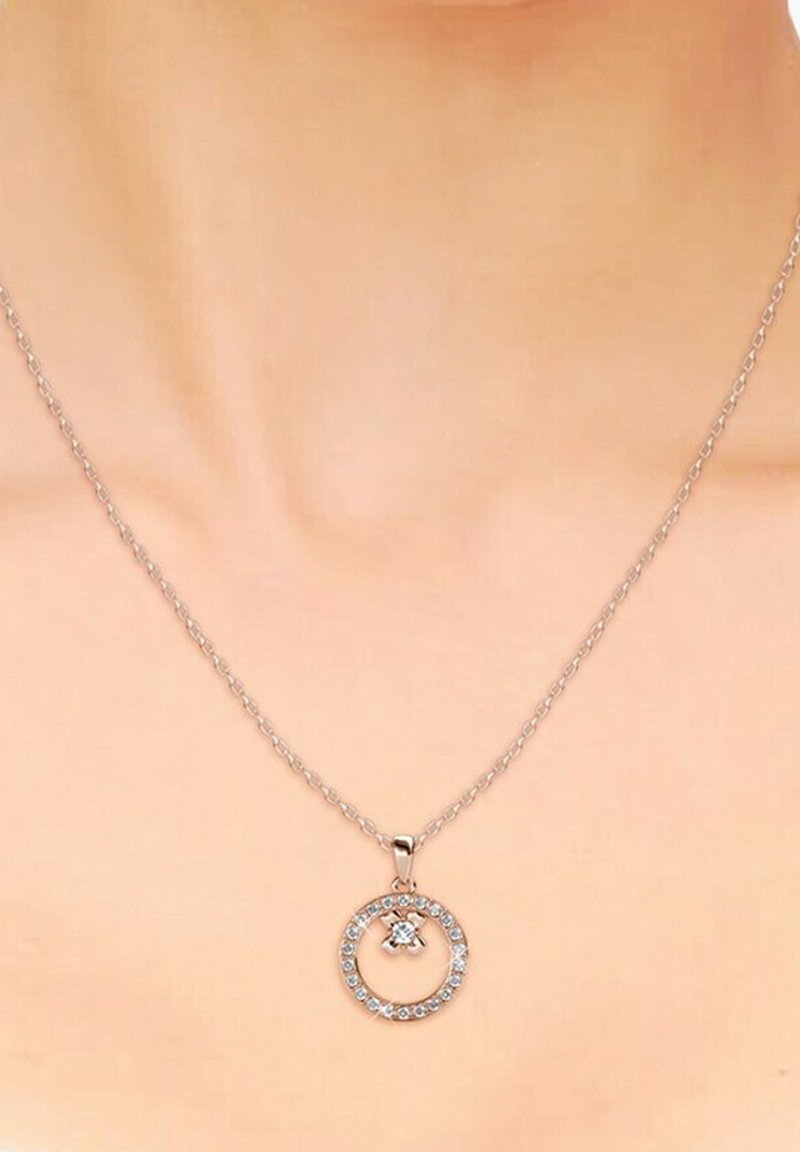 Collana in argento con pendente circolare decorato con cristalli trasparenti, che mette in risalto un gioiello centrale e un design circolare.