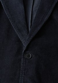 Navy corduroy blazer featuring a notched lapel, black button closure, and visible ribbed texture. Lined interior is partially visible.