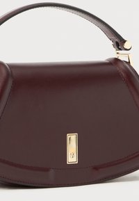 Burgundy leather handbag with a smooth texture, rounded shape, and a gold-tone hardware accent. Features a top handle for carrying.