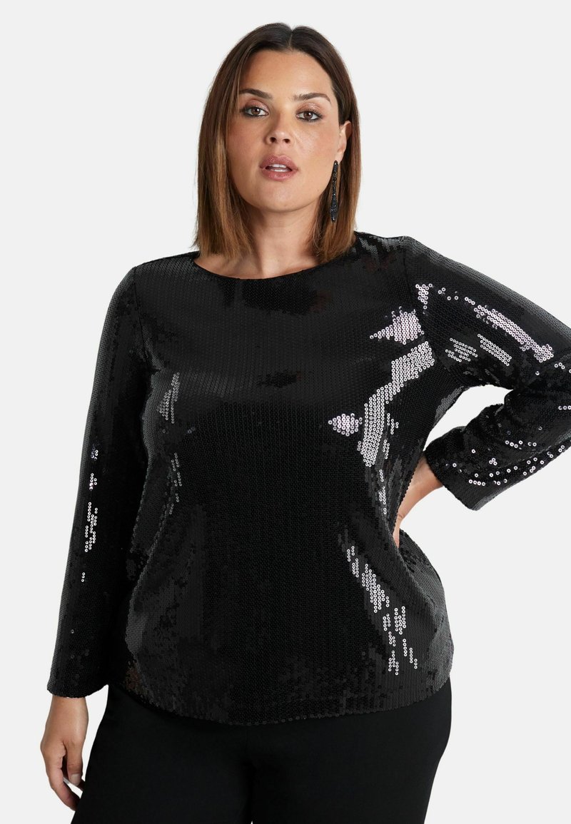 Top lungo con maniche a sbuffo in paillettes nere, con scollatura tonda e vestibilità rilassata, caratterizzato da una texture lucida che riflette la luce.
