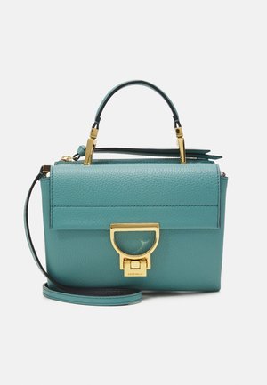 Sac à main en cuir bleu sarcelle avec poignée supérieure, fermoir doré et bandoulière amovible sur fond blanc uni.