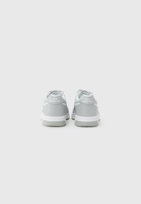 Sneaker grigie con una toma liscia in materiale sintetico, dettagli bianchi, inserto in rete e suola in gomma texturizzata. Presentano un design a punta bassa e un collare imbottito.