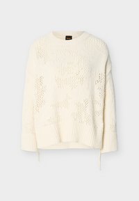Πλεκτό πουλόβερ σε κρεμ απόχρωση με στρογγυλή λαιμόκοψη, μακριά μανίκια, ριμπ μανσέτες και τελείωμα, με διακριτικό υφασμάτινο σχέδιο και λεπτομέρεια με κορδόνι.
