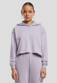 Felpa corta color lilla realizzata in tessuto morbido, con cappuccio, vestibilità ampia e polsini a costine. Presenta un design casual adatto per un abbigliamento rilassato.