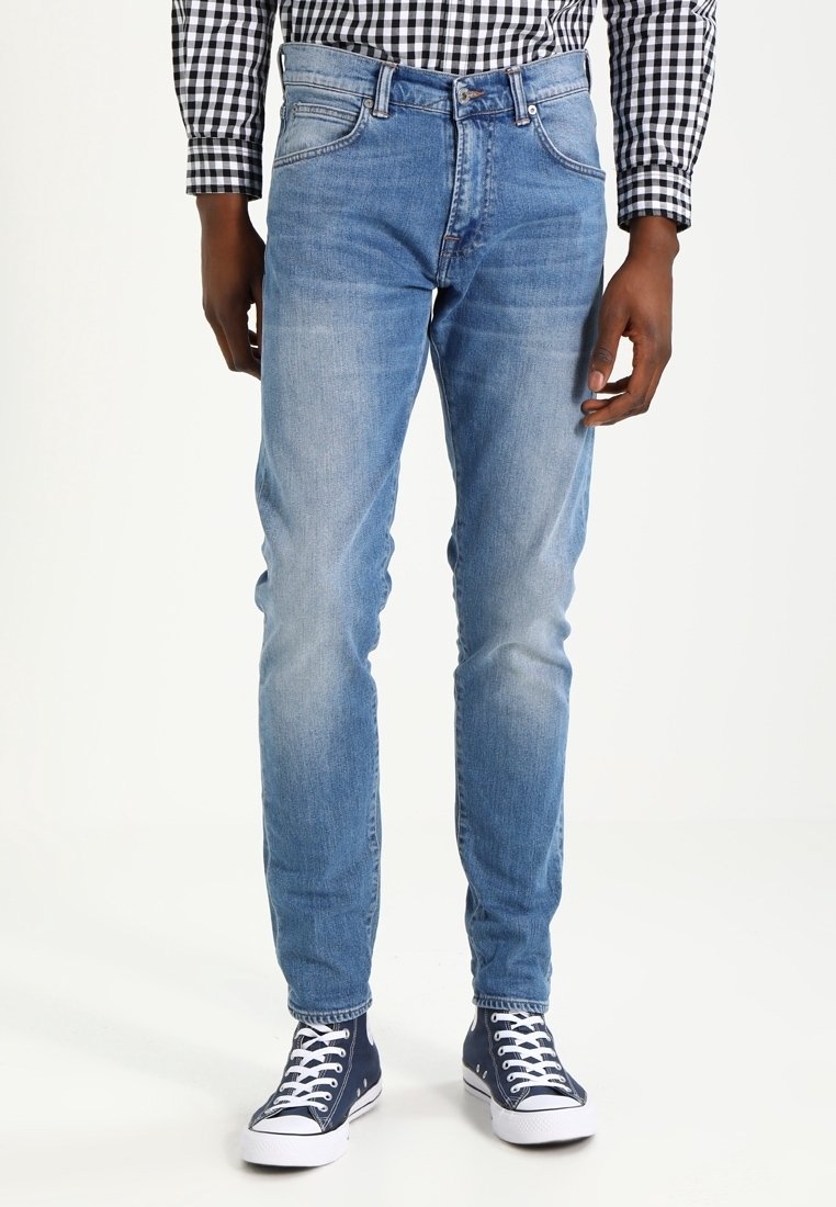 Light blue denim jeans with a slim fit, featuring front pockets and a mid-rise waist. Paired with blue low-top sneakers.