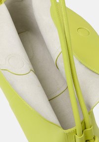 Zielona skórzana torebka o gładkiej fakturze i dwóch wąskich uchwytach. Wnętrze wykończone jasnobeżowym materiałem z delikatnym wzorem.