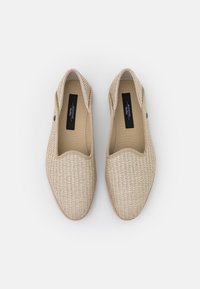 Beiga slip-on skor med övre i vävt tyg, rundad tå och tan fodring. Har minimal hårdvara och en mjuk, strukturerad yta.
