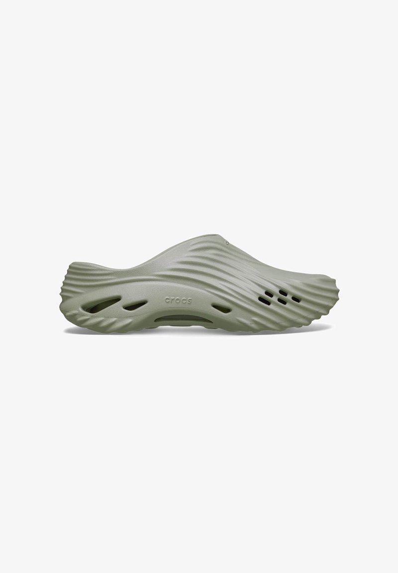 Chaussure à enfiler vert olive avec texture ondulée, plusieurs trous de ventilation et logo "crocs" sur le côté de la semelle.