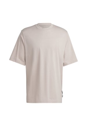 Gładki, jasnobeżowy t-shirt z krótkim rękawem i okrągłym dekoltem, o luźnym kroju, z małą metką na lewym bocznym szwie.