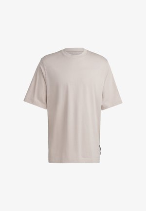 Gładki, jasnobeżowy t-shirt z krótkim rękawem i okrągłym dekoltem, o luźnym kroju, z małą metką na lewym bocznym szwie.