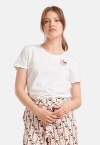 Witte katoenen t-shirt met een ronde halslijn en korte mouwen, voorzien van een klein, multikleurig abstract ontwerp op de borst.