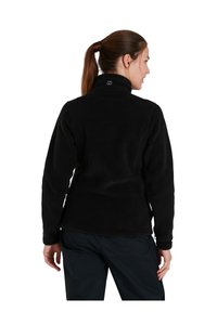 Veste en polaire noire avec un col haut, texture lisse, poches latérales et un détail de logo au niveau de l'encolure arrière.