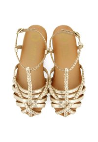 Sandalias doradas con tiras trenzadas, diseño de punta abierta y cierre en el tobillo. Base interna suave con marca en relieve.