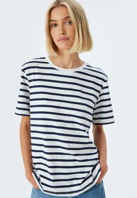 Bomulds T-shirt med marineblå og hvide vandrette striber, rund halsudskæring, korte ærmer og en afslappet pasform. Blød tekstur med sideskår.