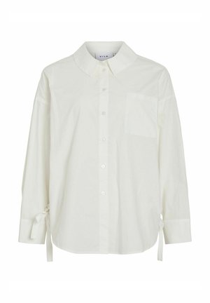 Chemise blanche boutonnée avec col, manches longues, accents de cravate aux poignets, et une poche poitrine. Fabriquée en tissu léger avec une texture lisse.