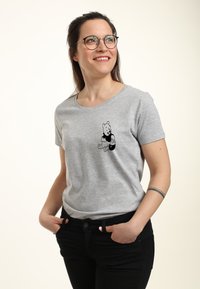 Szara bawełniana koszulka z krótkim rękawem, na której z przodu znajduje się czarny zarys graficzny niedźwiedzia siedzącego i trzymającego słoik miodu.