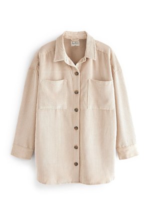 Veste-chemise beige en velours côtelé avec manches longues, deux poches poitrine et col à rabat.