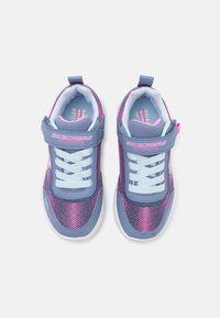 Zapatillas deportivas en morado y rosa con parte superior de malla, cierre de cordones y velcro, cuello acolchado y suela de goma blanca. Marca visible en el lateral.