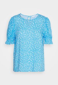 Blusa azul clara com mangas curtas bufantes, padrão floral em branco, decote redondo e pequena abertura em forma de buraco-chave nas costas.