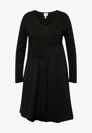 Zwarte jurk met lange mouwen, een v-hals en een elastische taille. Kenmerkt zich door een gelaagd ontwerp met contrasterende texturen en een vloeiende silhouet.