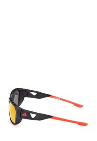 Okulary przeciwsłoneczne z czarną ramą i czerwonymi akcentami, z kanciastymi elementami designu oraz  żółtymi soczewkami. Teksturowane matowe wykończenie na ramionach.