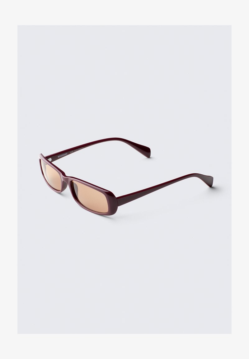 Óculos de sol em borgonha com armações retangulares, lentes degradê e hastes elegantes. O material tem um acabamento suave e brilhante.