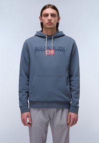 Capuchon sweatshirt in blauw-grijze stof met een voorzak, voorzien van een print van de merknaam en een Noorse vlag. Koorden in het wit.