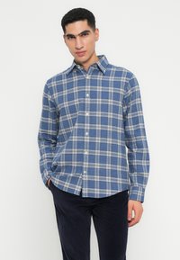 Blauw en wit geblokt overhemd met een button-down kraag, lange mouwen en een relaxed fit; gemaakt van zachte, gestructureerde stof.