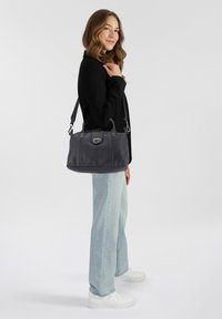 Sac à main en cuir gris foncé avec des poignées supérieures doubles et une bandoulière amovible. Équipé de quincaillerie en argent et d'une finition texturée.