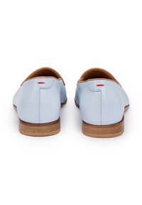 Chaussures en cuir bleu clair au design simple, avec un accent en cuir tan au niveau du talon et un petit détail rouge à l'arrière. Semelle plate en bois.