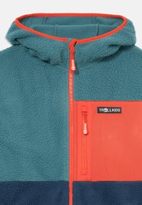 Fleece jacket with a teal upper, orange accents, and navy lower section. Features hood, front zipper, and logo on chest pocket.