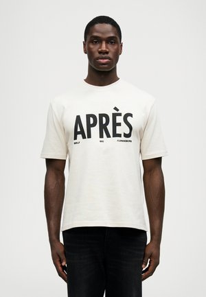 T-shirt de manga curta creme com texto em preto em destaque "APRÈS GOLF SKI J.LINDBERG" na parte frontal. Gola redonda e corte descontraído.