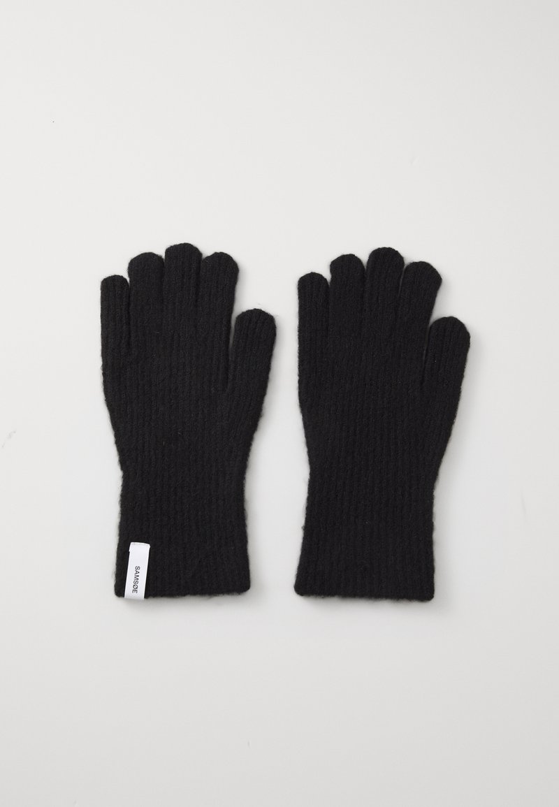 Guantes de punto negro con nervios, con cinco aberturas para los dedos y una pequeña etiqueta blanca en la zona de la muñeca. Textura suave.
