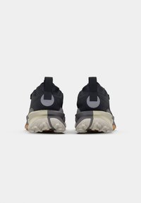 Black athletic shoes featuring a textured upper, prominent heel tab, and a two-tone sole with rubber traction patterns.