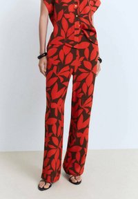 Red and brown patterned matching top and wide-leg pants, featuring a leaf design, short sleeves, and buttons on the top.