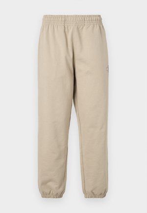 Beige joggebukser med elastisk midje og mansjetter. Mykt bomullsmateriale, rett ben-design, med en liten brodert logo på siden.